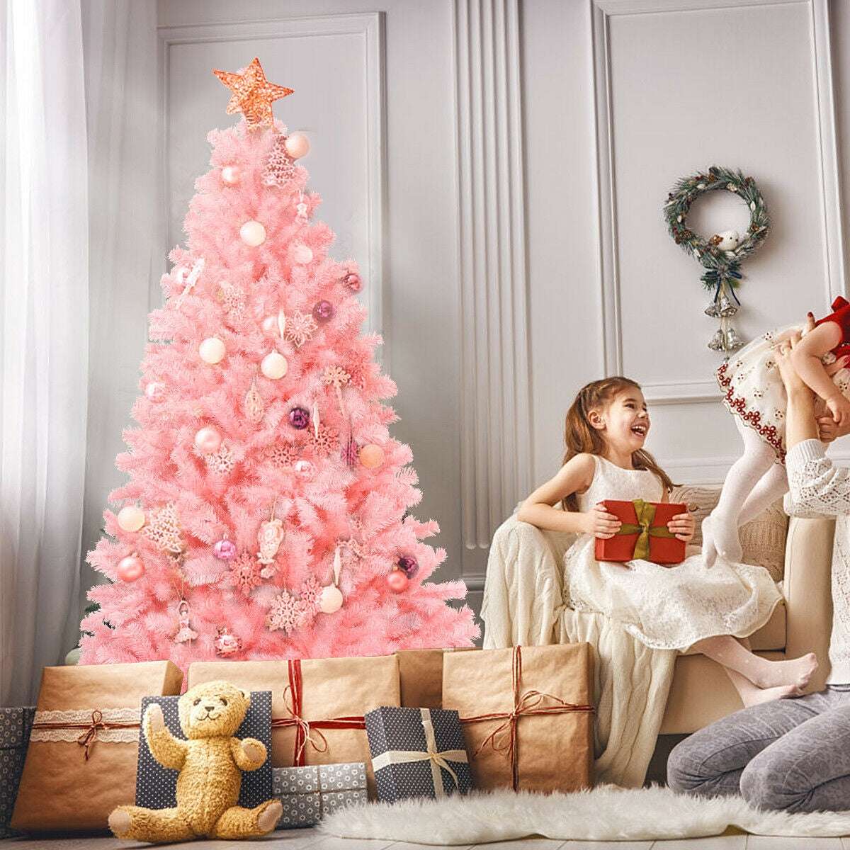 Pink artificial Christmas tree decorated with ornaments and a star topper