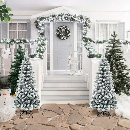 Two snow-flocked pencil Christmas trees with black metal stands