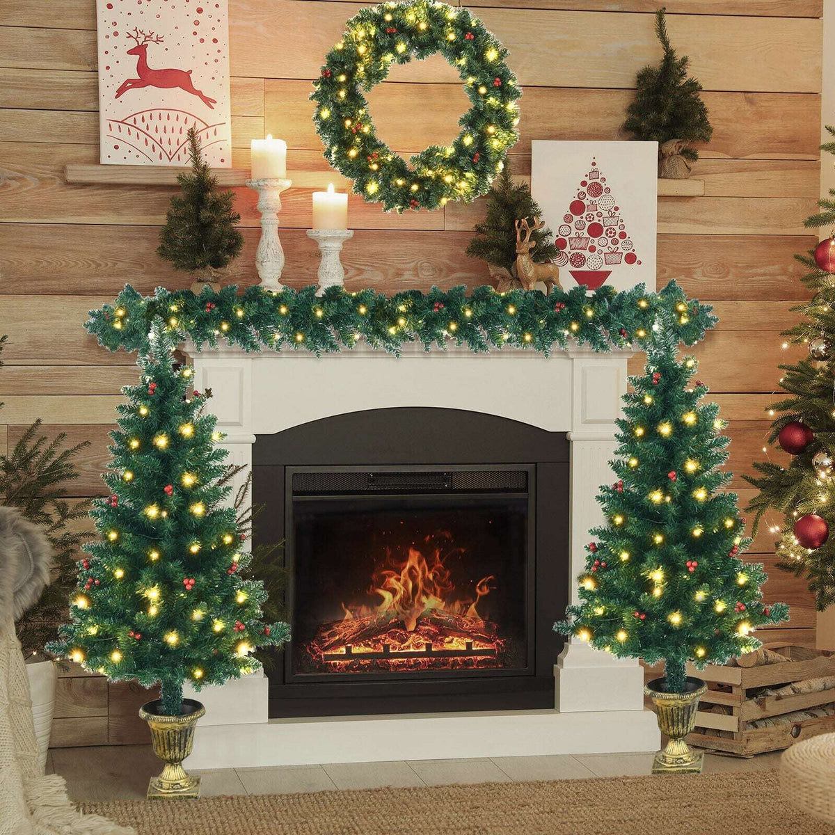 Pre-lit Christmas trees, wreath, and garland arranged around a fireplace