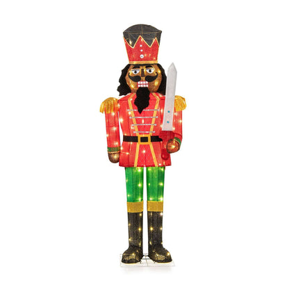 Full view of the lighted nutcracker with crown hat, red coat, green trousers, and sword