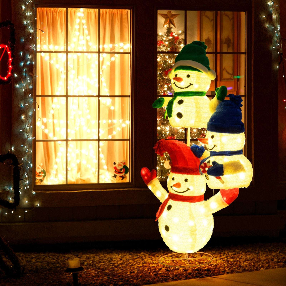 Lighted three-snowman Christmas decoration on a circular metal base