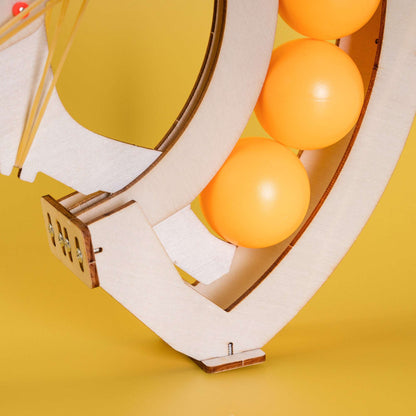 Wooden ball launcher frame loaded with orange balls and curved ball track