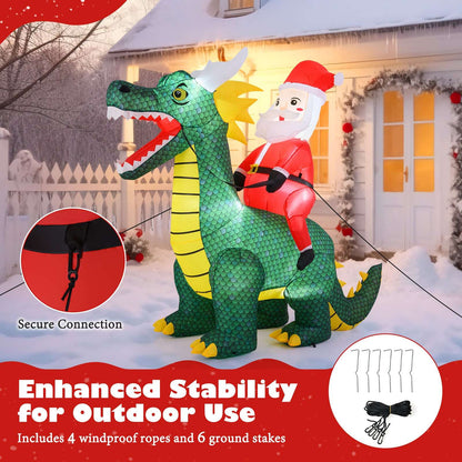 Inflatable Santa riding a green dinosaur with securing ropes and ground stakes