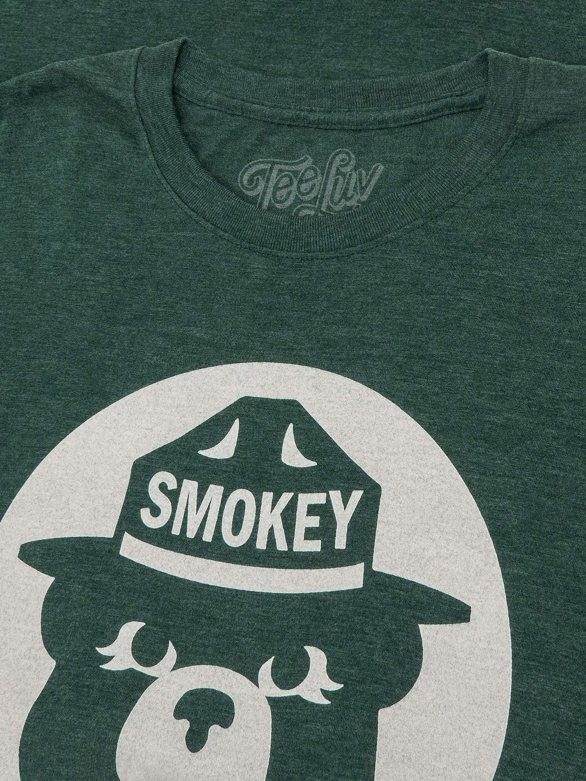 Forest green T-shirt close-up of Smokey Bear hat and front logo graphic