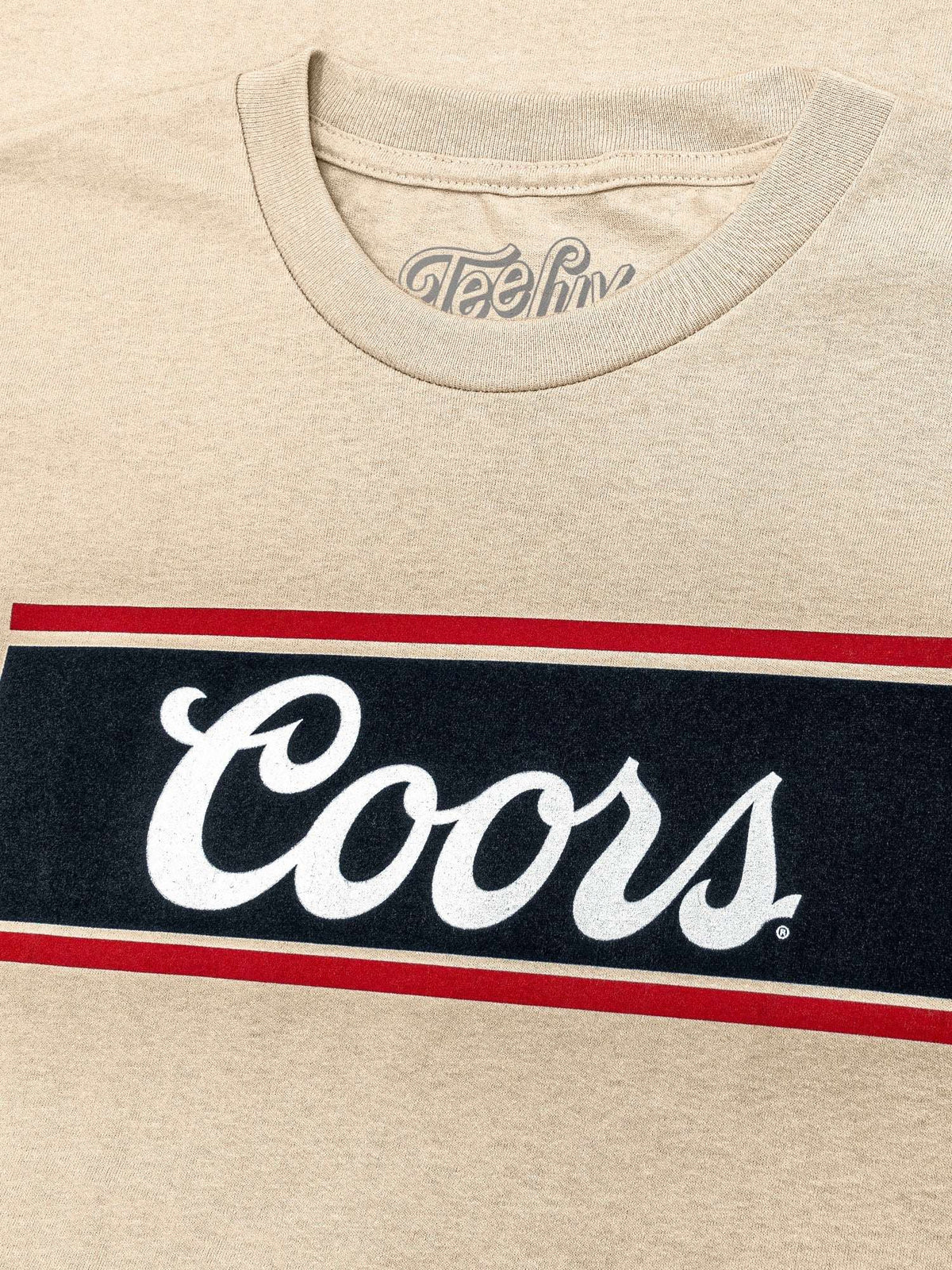 Cream T-shirt neckline and large Coors wordmark with red stripes