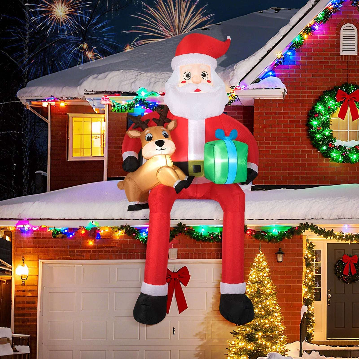 Inflatable Santa holding a reindeer and gift, displayed above a garage