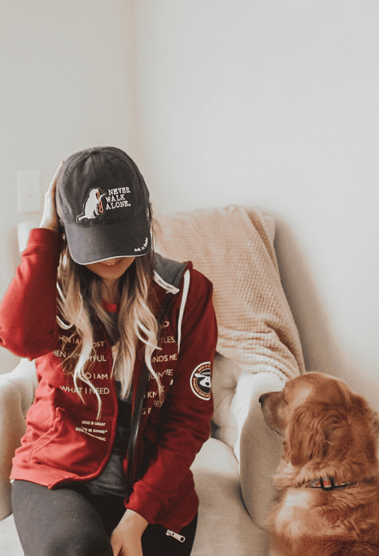 Dark gray baseball cap with white dog felt applique and 'Never Walk Alone' text