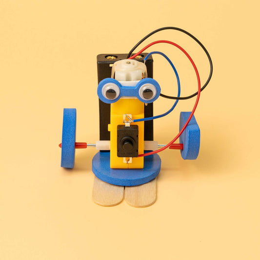 DIY robot kit figure with yellow body, blue wheels, and red/blue/black wiring