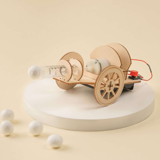 Wooden DIY STEM cannon kit with tabletop cannon model and several white launch balls