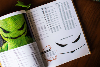 Open knitting guide with a green knitted face project and a facial features template