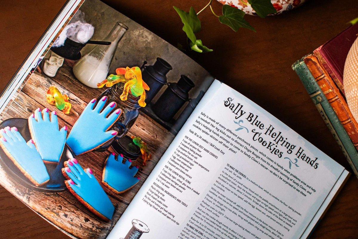 Open cookbook showing blue hand-shaped cookies and a Sally cookie recipe