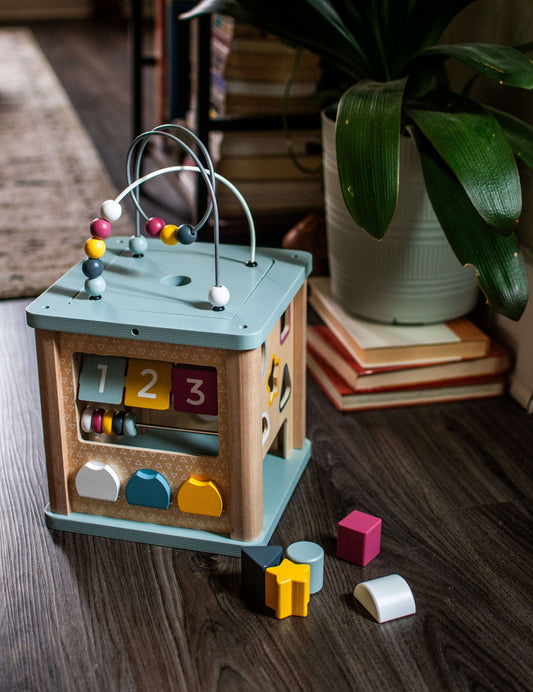 Wooden activity cube with bead maze and number slider panel