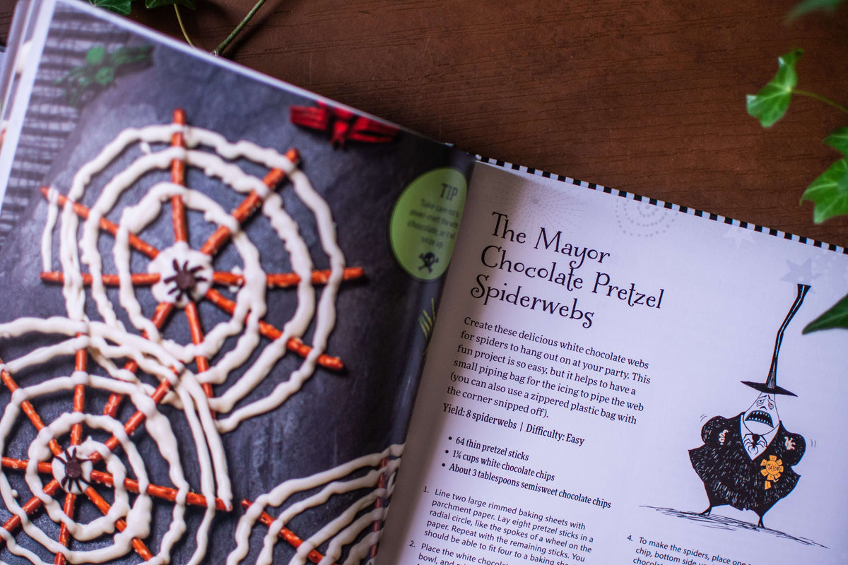 Open cookbook page with a chocolate pretzel spiderweb recipe and spiderweb pretzel photo