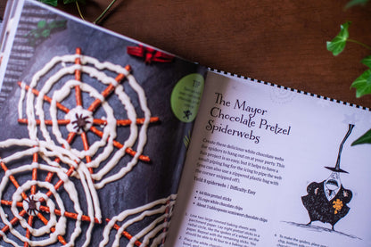 Open cookbook page with a chocolate pretzel spiderweb recipe and spiderweb pretzel photo