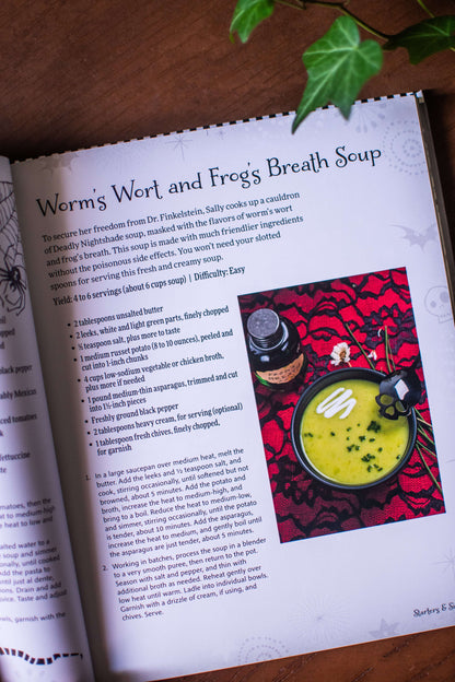 Open cookbook page featuring a recipe for Worm's Wort and Frog's Breath Soup with a soup photo