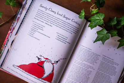 Open cookbook spread with a Sandy Claws iced sugar cookies recipe and Santa illustration