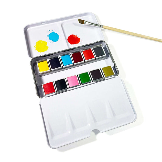 Compact watercolor paint set with open metal palette, 12 color pans, and brush