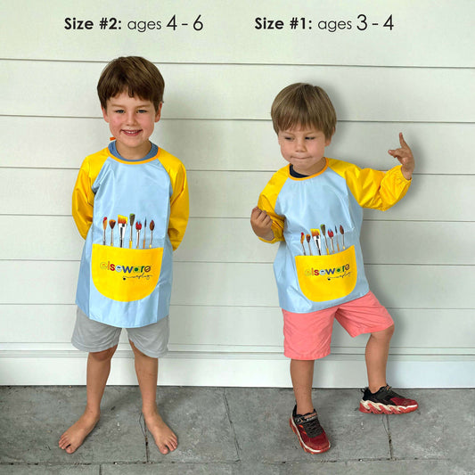 Kids art smock worn by children, light blue with yellow sleeves and front paint pocket