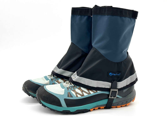 Mid-length waterproof gaiters in blue and black with ankle strap on hiking boot