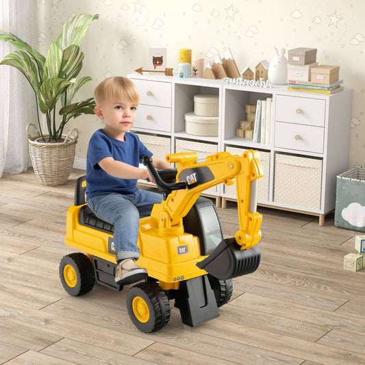 Yellow kids ride-on excavator with black backhoe arm and bucket, indoors