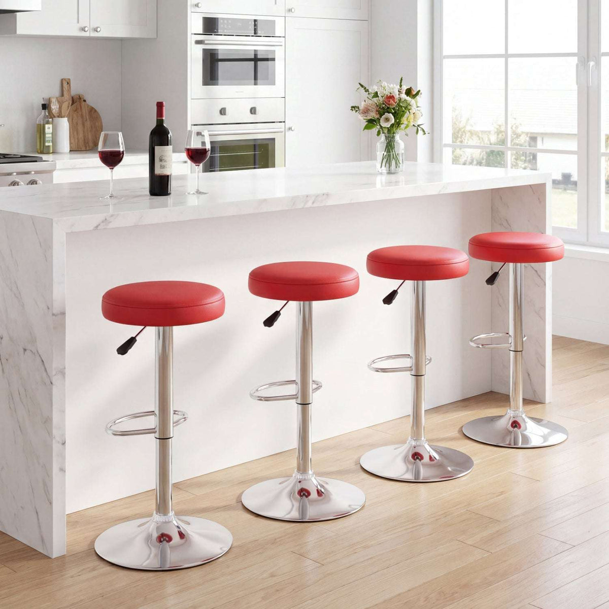 Four red adjustable bar stools with padded seats and chrome pedestal bases
