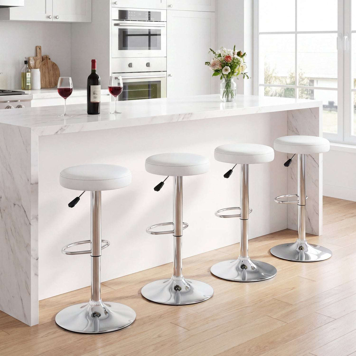 Four white adjustable swivel bar stools with round seats, chrome bases and footrests.