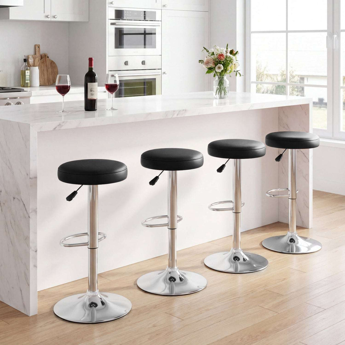Four black adjustable swivel bar stools with padded seats, chrome pedestals and round bases