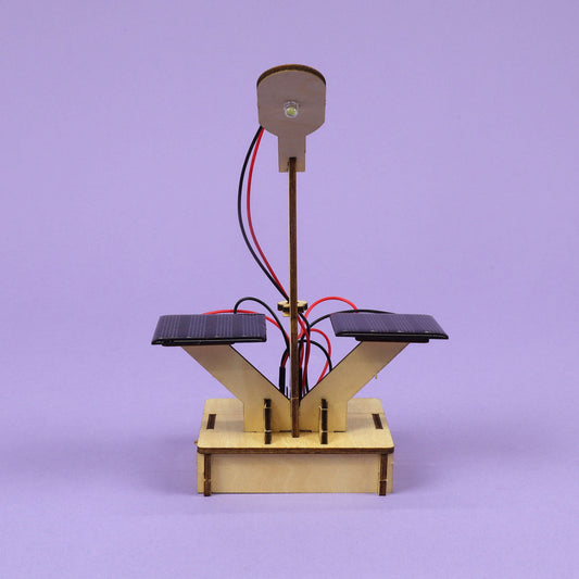 Solar lamp DIY kit with vertical wooden post, two solar panels, and red/black leads.