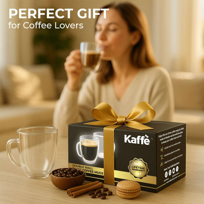 Clear glass coffee mugs with handles, one held up with gift box nearby