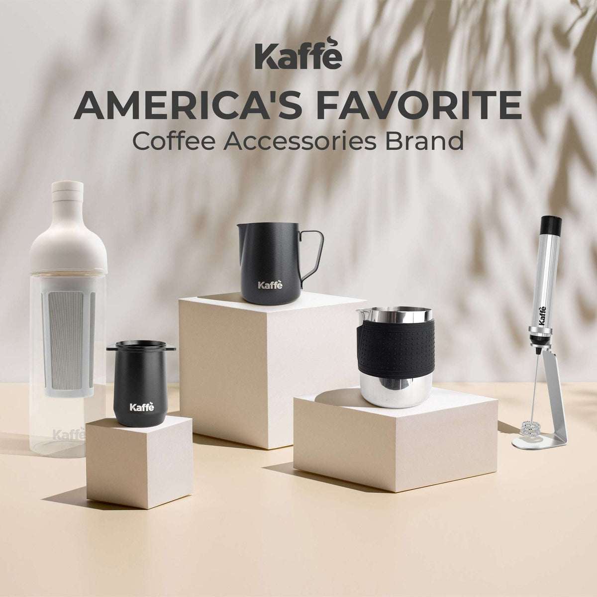 Kaffe stainless steel milk frothing pitcher with black silicone sleeve on countertop