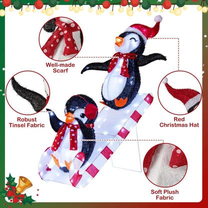 Pre-lit penguin decoration with plush fabric, red scarves, and Santa hats