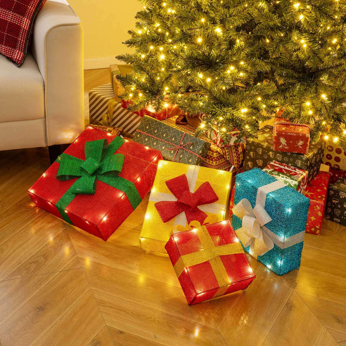 Four illuminated decorative gift boxes displayed separately on the floor