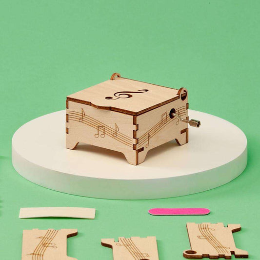 Wooden DIY music box kit with music note cutouts and crank mechanism
