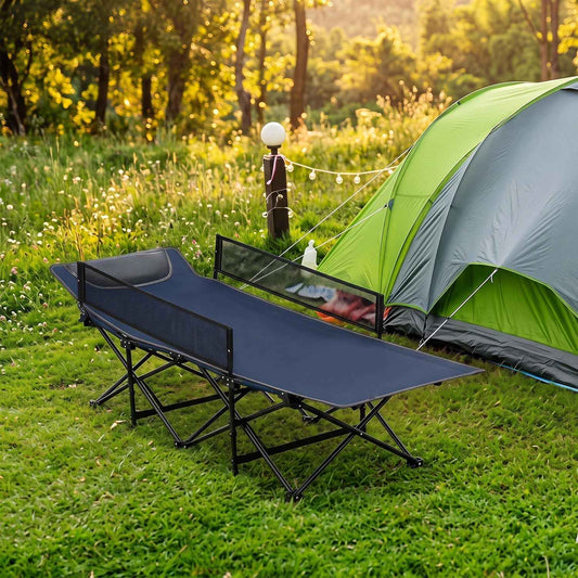 Navy portable folding camping cot with guardrail on grass, dark blue padded bed