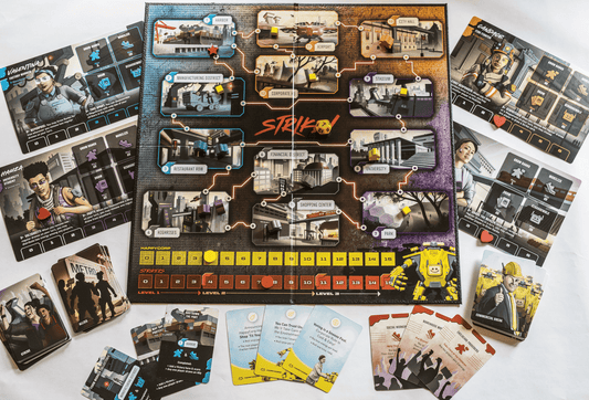 Strike! board game setup with rule cards, player boards, and colorful wooden pieces