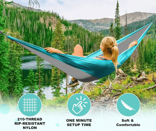 Blue nylon hammock stretched between trees, with two people lounging