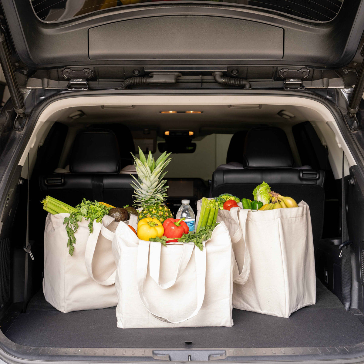 Off-white canvas jumbo tote bags in car trunk, long handles, square shape
