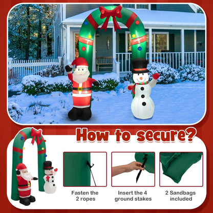Christmas inflatable arch with Santa and snowman; setup guide shows ropes, stakes and sandbags