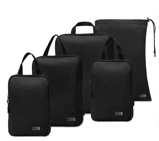Black compression packing cube set with three cubes and a tall drawstring bag