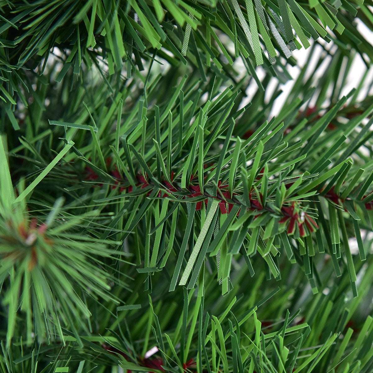 Close-up of green PVC needles and branch ties on the artificial Christmas tree