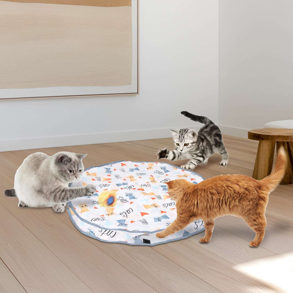 Interactive cat play mat on floor as cats bat at fuzzy ball toys