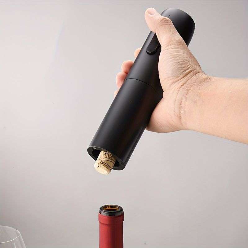 Handheld electric wine opener removing a cork from a wine bottle