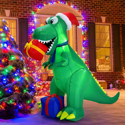 Green Christmas inflatable dinosaur wearing a Santa hat and holding a red gift, with LED lights