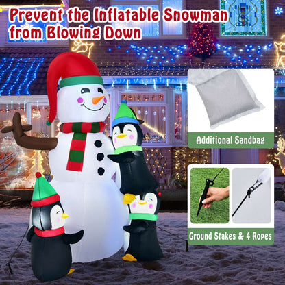 Inflatable snowman with three penguins, ground stakes, ropes, and a sandbag