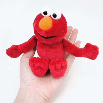 Small Elmo plush beanbag toy resting in a person's hand
