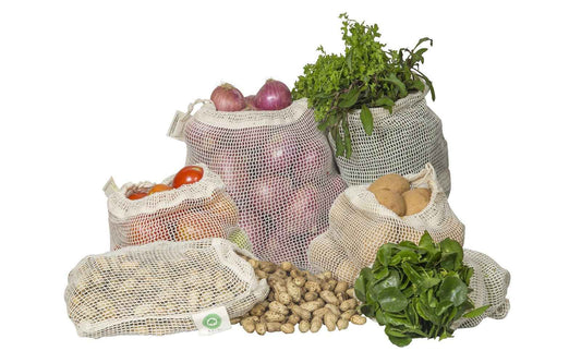 Pack of cotton mesh produce bags with drawstrings, shown with vegetables and herbs
