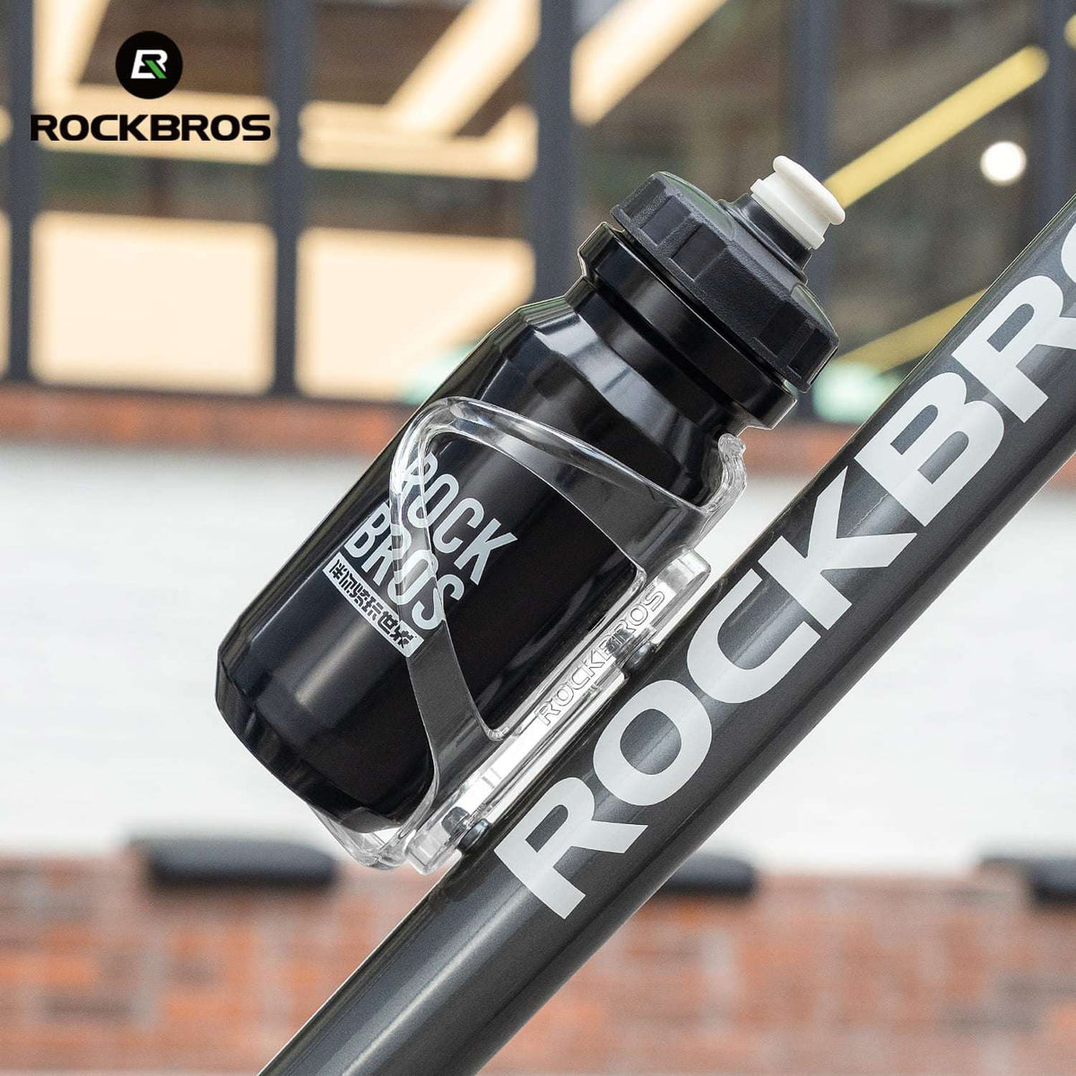 Bicycle water bottle cage holding a clear water bottle on a bike frame.