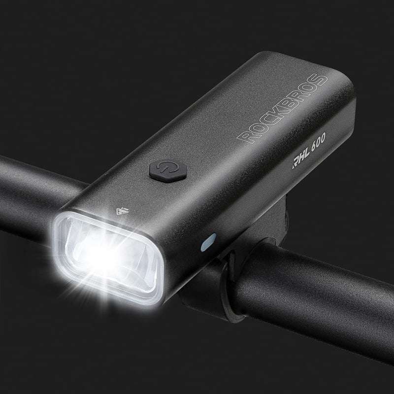 Black front bike light with bright white square lens mounted on handlebar