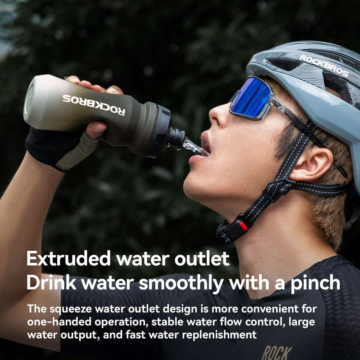 Gray bike water bottle with drinking spout, held near a rider’s mouth