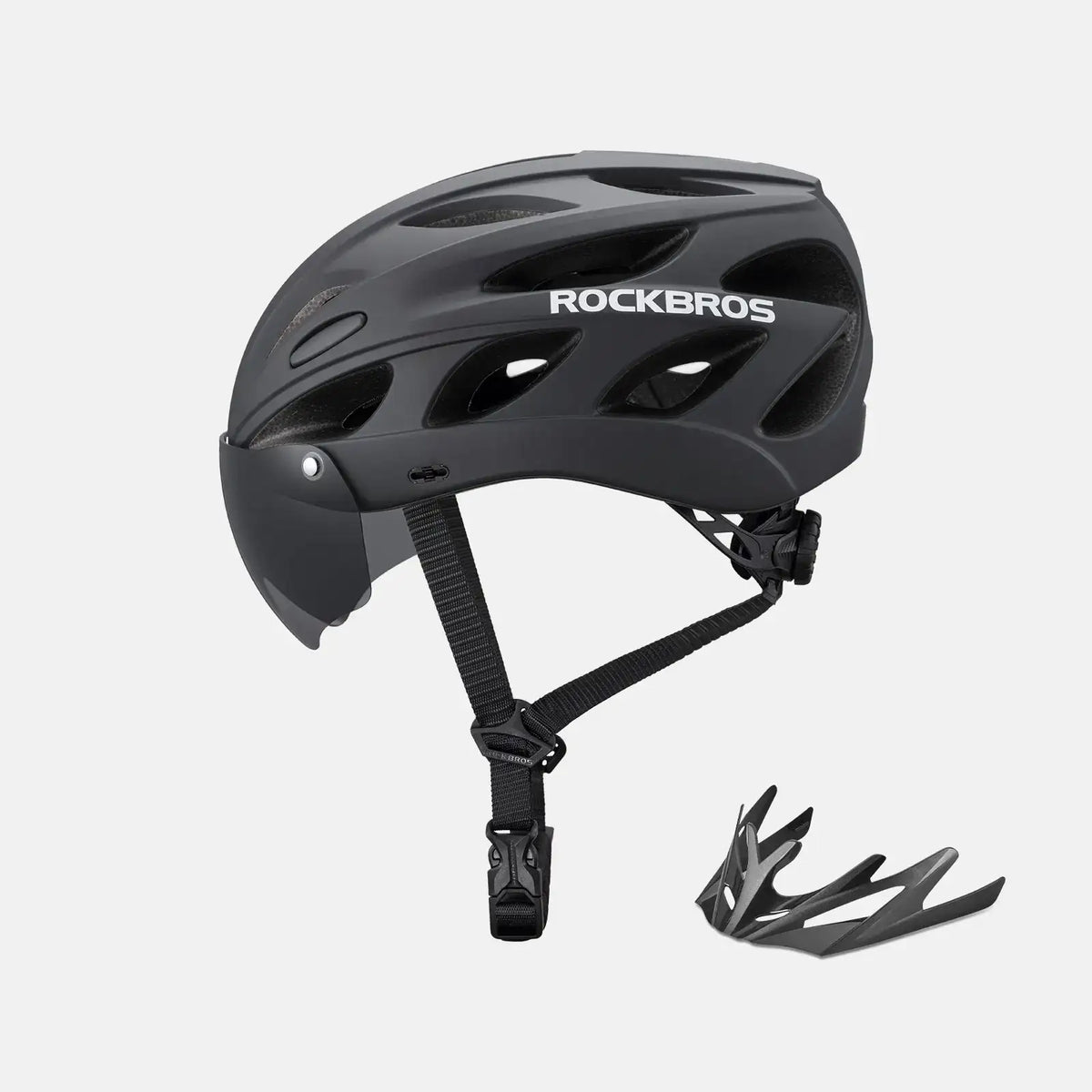 Black bike helmet with dark visor, adjustable chin strap, and included goggles accessory